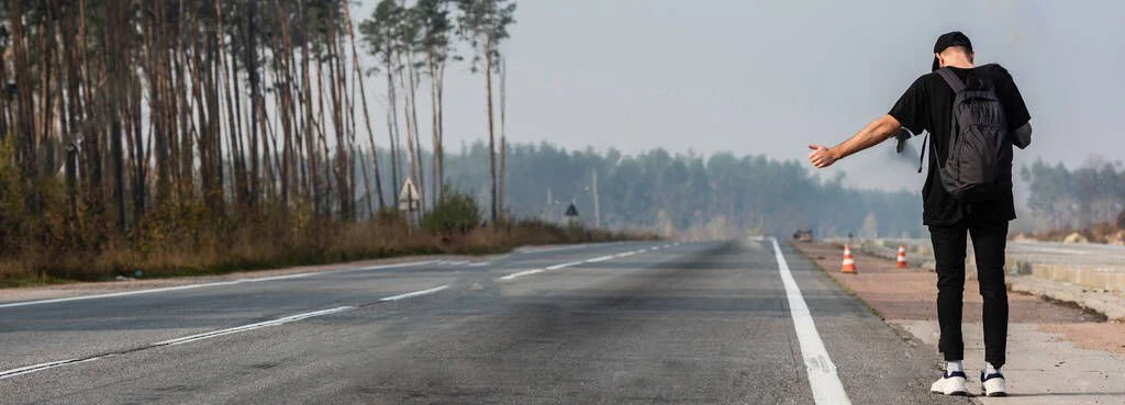 Musicista di strada con chitarra davanti alla Renault 4